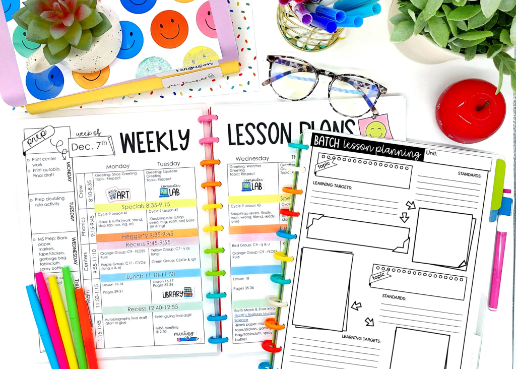 A colorful planner opened to a weekly lesson plan for the week of December 7th, featuring sections for Monday through Wednesday, including subjects like art and library, along with additional blank lesson planning pages. Surrounding the planner are colorful pens, a succulent plant, glasses, and a red apple.